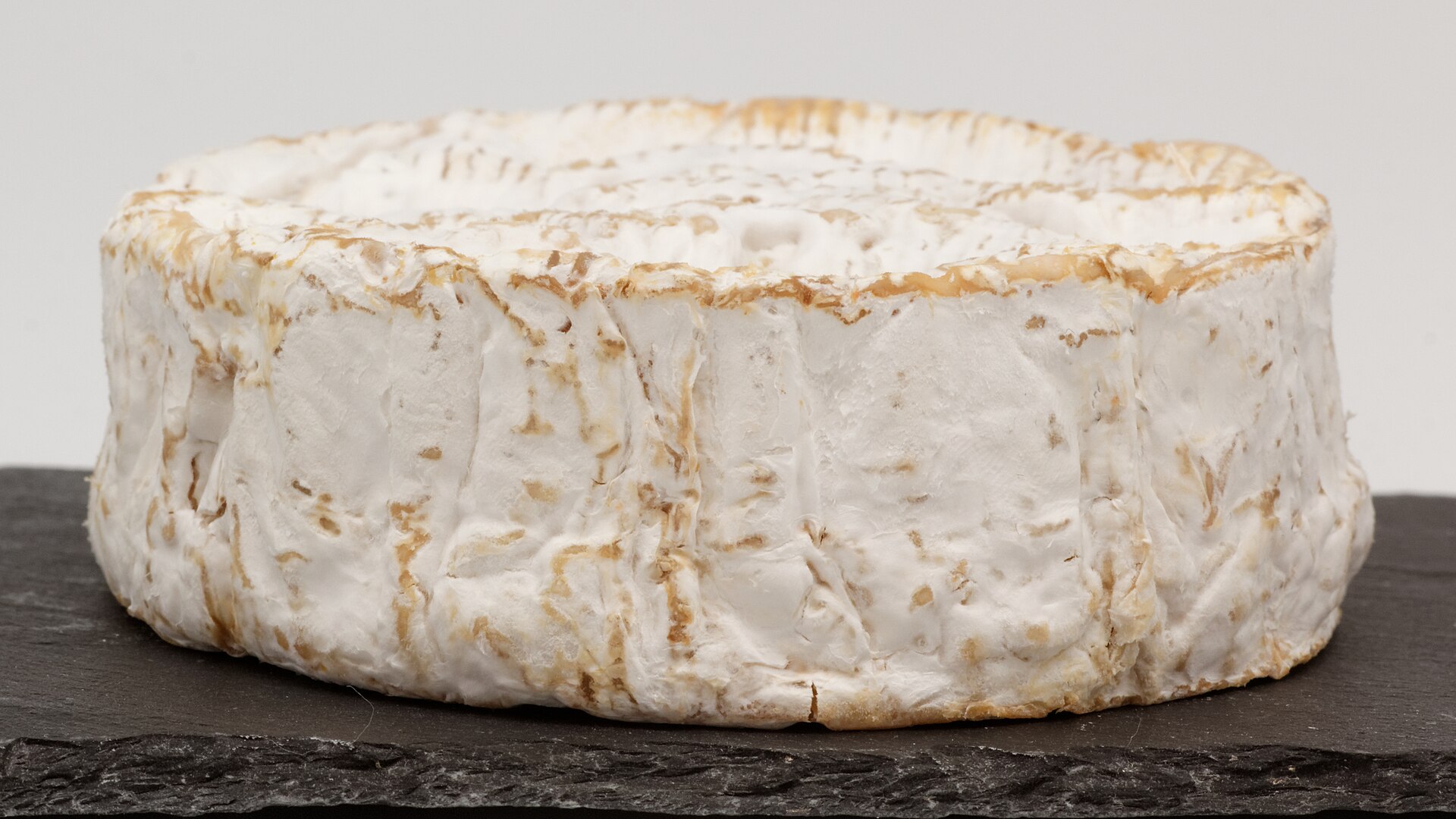Un camembert de Normandie entier posé sur une ardoise