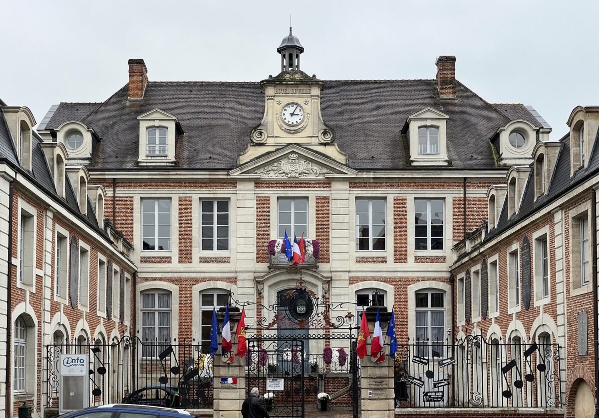La façade de l'hôtel de ville de Lisieux, avec son horloge et ses drapeaux