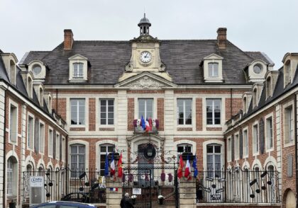 La façade de l'hôtel de ville de Lisieux, avec son horloge et ses drapeaux