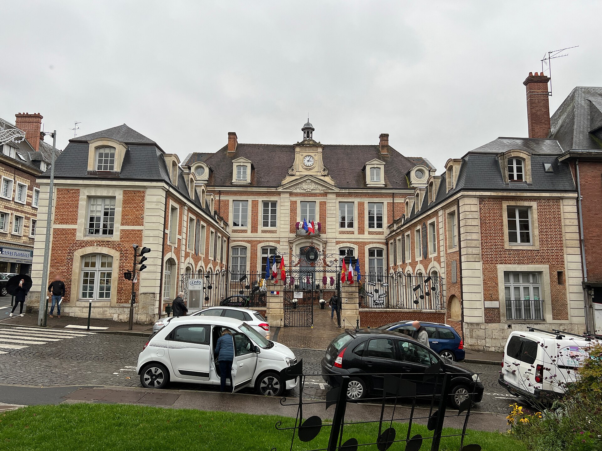 Des voitures stationnées devant l'hôtel de ville de Lisieux