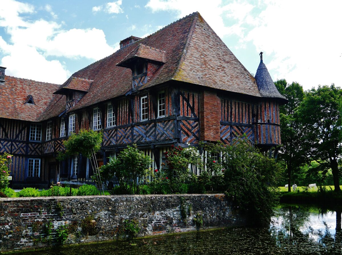Les deux ailes à pans de bois du manoir de Coupesarte au-dessus des douves